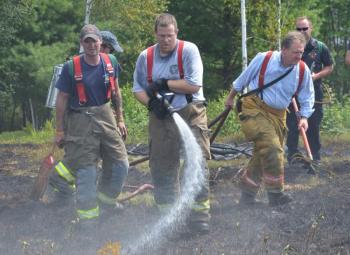 Rockport firefighters Levi Rollins,Neal Bartley and Lt. Bill Lane with Chief Jason Peasley in the background, respond to an out-of-control fire in a West Rockport blueberry field Tuesday afternoon. (Photo by Lynda Clancy)