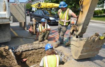 For a while, it was a real puzzle, trying to locate the pipe that led on the Mechanic Street water main. It took a few days of digging and sleuthing, and then it was shovel on metal, approximately four feet down beneath layers of tarmac, rocks and dirt. Eric Kenefick, Shaun McNulty and Lee Philbrook find the pipe using a resonator, computer coordinates and muscle power. (Photo by Lynda Clancy)
