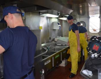 Breakfast clean-up, Sept. 10. Foul weather gear is always handy. (Photo by Lynda Clancy)