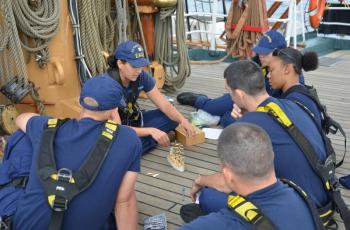 Crew member Lawren Hill-Hand teaches seamanship to OCs on the forecastle of the Eagle.