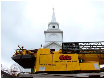 A crane stands outside Stockton Springs Community Church, Oct. 18 after installing a new spire, the last piece of the rebuilt steeple. (Photo by Ethan Andrews)