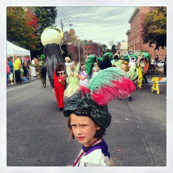 A plumed promenader looks back as the parade heads into town. (Photo by Ethan Andrews)