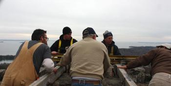 Facing from left, Ryan Fisher and Tom Bland working outside the tower, up in man lift, while Jim Hamilton, Tom Jackson and Randy Stearns work inside the top of the tower. (Photo by Holly S. Edwards)