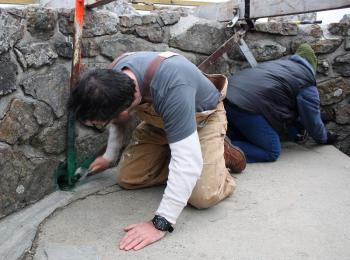 From left, Jim Hamilton and Mary Carver work back to back tightening nuts on bolts that will help the star on the tower. (Photo by Holly S. Edwards)