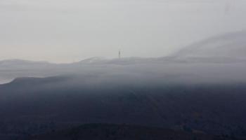 A communication tower appears through the clouds in the distance Saturday morning. (Photo by Holly S. Edwards)