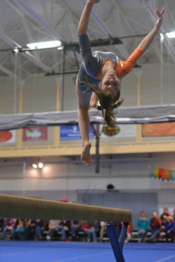 Ashley Kenniston does a backwards flip off the balance beam. (Photo by Ron Hawkes)