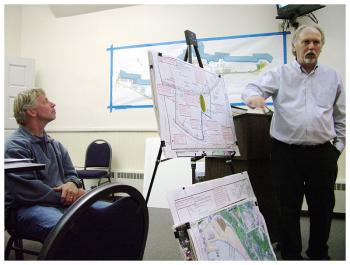 City Planner Wayne Marshall, right, shows plans for revisions to relief walkways at Front Street Shipyard. At left, Shipyard President JB Turner. (Photo by Ethan Andrews)