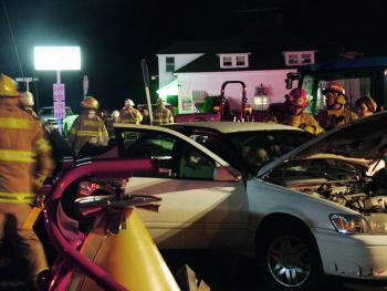Firefighters work to free the driver of the Toyota Camry from his vehicle roughly 45 minutes after the crash. (Photo by Ethan Andrews)
