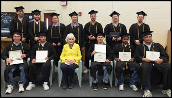 Doris Buffett (center) sits with the 2013 graduating class. The graduates are, in no particular order, Jerry James Banks, Brandon Sobosie Brown, Steven M. Clark, Jon James Dow, Sergio Stephen Haitston, Robert Alan Payzant, Daniel P Roberts, Dale Allen Wood, Jon Brent Dyer, Edwin Devaughn Keys, Victor E. Loveitt, Joseph Billings Rouleau and Christopher David Shumway.