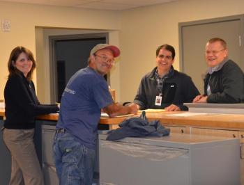 Poring over the last-minute details at the renovated and expanded Lincolnville Town Office: Amanda Austin, architect, and Mike Paris, contractor, on the left side of the counter. On the right, Architect Steve Marin and Town Administrator David Kinney. (Photo by Lynda Clancy)