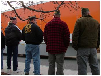 Veterans watch as the convoy of wreath-bearing trucks rolls into Belfast, Sunday. (Photo by Ethan Andrews)