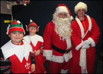 Santa Claus, Mrs. Claus and elves visit the riders of the Jingle Bell Express during one of the trips Friday night, Dec. 6. (Photo by Chris Wolf)