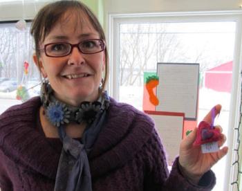 Teisha Hufnagel Jones, education outreach and membership coordinator of the Good Tern, displays a felted heart ornament made by Kate Chandler of Orange Iron Studios, also a member-owner. (Photo by Kay Stephens)
