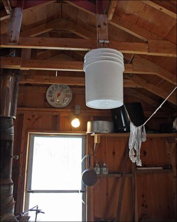 ‘Since heat rises, I thought I would hang a frozen bucket of sap in the rafters to see if I could get it to melt,’ said Tom Cox of Rockport Tuesday. (Photo by Holly S. Edwards)