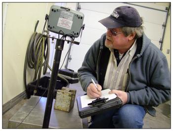 Wiggin checks the reading on a large scale at Maine Maritime Products in Belfast. On the scale bed is a single 50 pound weight. (Photo by Ethan Andrews)