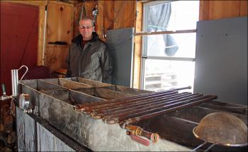 Hobby maple syrup producer Tom Cox of Rockport inside his sugarhouse near Simonton Corner Tuesday. Last year his boiling operation yielded 46-1/2 gallons of syrup. This week, the cold has stymied his progress due to hundreds of gallons of frozen sap. (Photo by Holly S. Edwards)