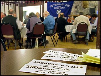 Bumper stickers supporting Searsport’s commercial port displayed at a meeting of the Propeller Club of Searsport and Bucksport, March 19, at the Belfast Shrine Club. The group heard from Captain David Gelinas of the Penobscot Bay and River Pilots Association about a dredging proposal that would enlarge the deep-water shipping channel at Mack Point. (Photo by Ethan Andrews)