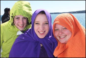 UMaine students Kaylee Cochrane, of Clinton; Jordan Leadwith, of North Adams, Mass.; and Jenny Fletcher, of South Portland, try to stay warm on the chilly ferry ride to Vinalhaven.