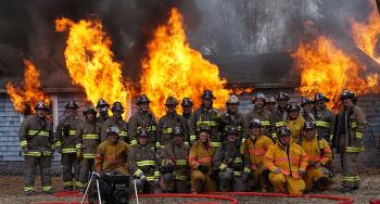 Members of the Rockport Fire Department pose Sunday morning during the final fire that was allowed to finally consume the donated training structure on Route 90. (Courtesy Lincolnville Deputy Fire Chief Mike Eugley)