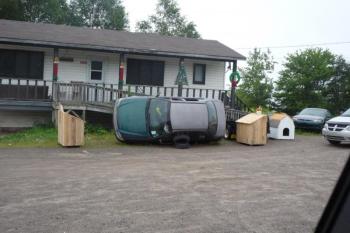 In Willimantic, I met a low-income middle-aged man working on replacing his automobile's exhaust system and transmission that he proclaimed were "pooched." Since he didn't have jacks or blocks, the vehicle, drained of all fluids, was tipped on its side. Deflated tires were wedged under the doors to prevent the vehicle from rolling over. A Chilton's Auto Repair Manual sat open on top of a block of wood for easy reference. (Photo by Ron Joseph)