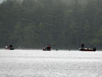 Camden Fire Department rescue swimmers Todd Anderson and Cheyne Hansen join boats searching for this missing sculling boat rower on Megunticook Lake Tuesday morning. (Photo by Holly S. Edwards)