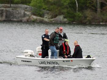 Camden Fire Department rescue swimmers Todd Anderson and Cheyne Hansen are brought back to shore by Lake Patrol Officer Justin Twitchell, along with Camden Police Officer Wes Butler and Camden Fire Asst. Chief Andrew Lowe. (Photo by Holly S. Edwards)