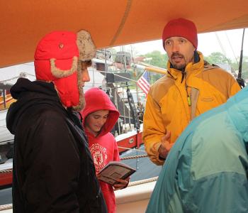 Appleton Village School eighth-grade homeroom teacher Than Porter hands out composition books to students and instructs them in their journaling task. ‘Write about what you expect to get out of this trip aboard the Mary Day,’ said Porter. (Photo by Holly S. Edwards)