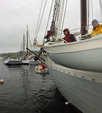Schooner Mary Day First Mate Rebecca Johnson mans one of the small boats to begin moving the big engine-less schooner out of Camden Harbor Wednesday morning. (Photo by Holly S. Edwards)
