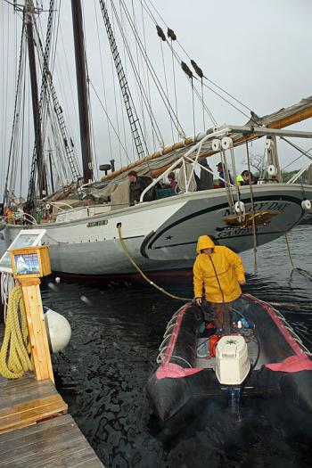 Capt. Jen Martin, wife of Capt. Barry King. mans another small boat to assist in moving schooner Mary Day off its mooring at the head of Camden Harbor. (Photo by Holly S. Edwards)