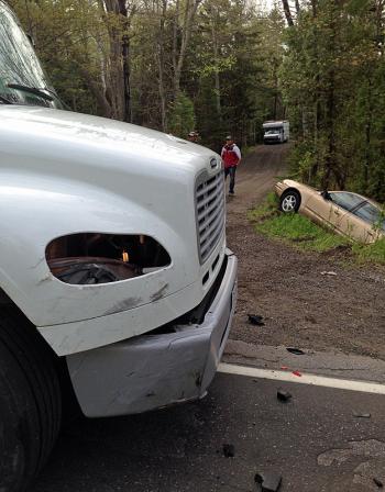 The Freightliner truck rear-ended this 1999 Oldsmobile Alero, sending it sliding off the road.