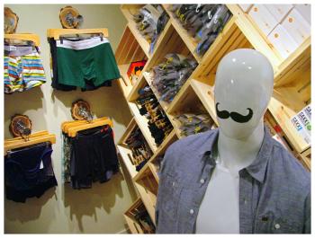 A mustachioed mannequin in a custom tailored shirt — part of a range of men’s clothes, from day-to-day wear to tuxedo rentals, offered at Man on Main. As the masculine counterpart to City Drawers, the new store, of course, stocks a large selection of underwear. (Photo by Ethan Andrews)