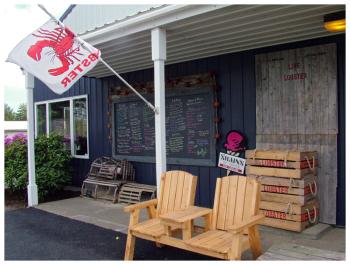 The menu board and some seating outside Off the Hook Shuckin’ Shack, a new takeout seafood business located at the Maine Maritime Products processing facility in the Belfast Business Park. (Photo by Ethan Andrews)