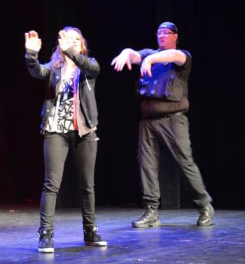 Local Star Justin Hills, an EMT, firefighter and police officer, ensures the peace on stage with Kea Tesseyman. (Photo by Lynda Clancy)