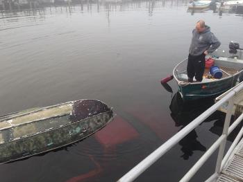 Justin Libby stands in a skiff looking over his sunken pickup truck and overturned skiff in Port Clyde early Thursday morning. (Courtesy Chris Chadwick)