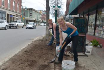 Meghan Lane, left, and Emily Lane, employees of the Grasshopper Shop, work on their day off getting the new landscaping in front of the store started. (Photo by Ron Hawkes)