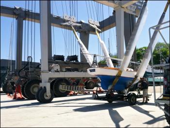 Workers at Front Street Shipyard launch a small sailboat with the company’s 160-ton travel lift. In the background, a crew readies the Shipyard’s 480-ton lift. (Photo by Ethan Andrews)