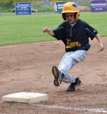 A Fisher player slides into third base. (Photo by George Harvey)