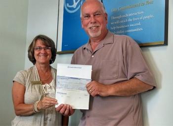 Connie Sawyer, branch manager in Rockland, presents a check to Gordon Page, executive director of Rockland Main Street, Inc.