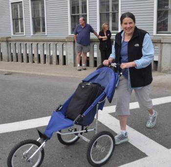 Photographer Marti Stone wheels her precious cargo — her cameras — across the street before the march. (Photo by Lynda Clancy)