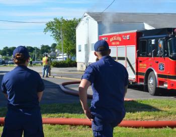 U.S. Coast Guard engineer Kyle Willette (on right), originally from WInslow, reported the fire Sunday morning, June 22. (Photo by Lynda Clancy)