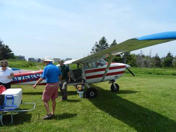 In the middle of the helicopter exercise came the regular scheduled mail flight to Criehaven! Penobscot Island Air pilot David Bellows flies the Cessna 206; pictured are Criehaven residents Skye and John Maher. (Photo by Eva Murray)