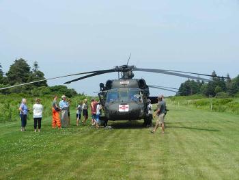 Each Maine Army National Guard Black Hawk helicopter carried four crew members. In this photo, Criehaven residents look over the bird. (Photo by Eva Murray)