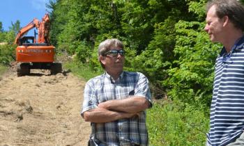 Tom Wells, owner of Royal Trail Works, and Landon Fake, director of parks and recreation for the town of Camden, confer about the Snow Bowl rebuild near the top of Ragged Mountain July 9. (Photo by Lynda Clancy)