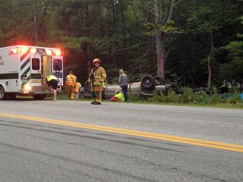 Union Ambulance personnel check on the driver and his passenger following the rollover crash in Union Tuesday evening. (Photo by David Edwards)