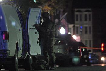 A tactical team member gets more equipment during the Camden Rite Aid Pharmacy standoff. (Photo by Holly S. Edwards)