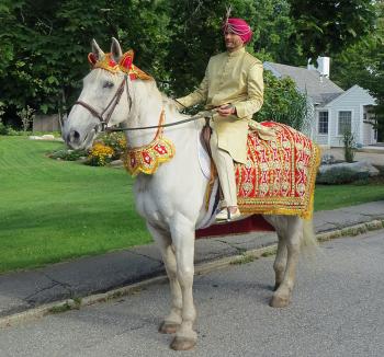 Johann, the groom, prepares to meet the family of his bride, Yasmin, walking in a procession on a white horse. (Photo by Richard Anderson)