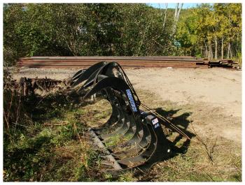 One of several pieces of equipment being used to pull up railroad tracks and ties in Belfast. In the background, a stack of rails. (Photo by Ethan Andrews)