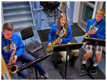 A saxophone trio, from left, Lucien Gordley-Smith, Alexis Racioppi and Jordon Bickford, plays for visitors in the stairwell of the BAHS art wing. (Photo by Ethan Andrews)