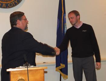 Will Clayton is congratulated by Stuart Sylvester following his swearing in as a city councilor. (Photo by Chris Wolf)