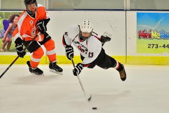 The Storm’s Maguire LeBlanc, right, in a superb effort, lays out in front of a Casco player to get to the puck first. Casco won the game 4-2. (Photo by Ron Hawkes)